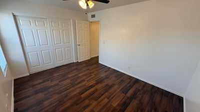 Well-appointed bedroom with ceiling fan, ample closet storage, and attractive flooring throughout. This comfortable space offers privacy and flexibility for residents seeking functional living areas.