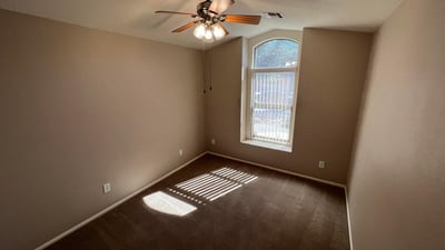 Flexible secondary bedroom with natural light, ceiling fan, and neutral finishes. Suitable for guests, family members, a home office, or additional living space in this inviting Goodyear home.