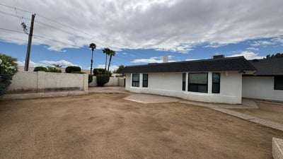 Expansive backyard with desert-friendly landscaping and multiple outdoor seating opportunities. The generous lot size provides flexibility for pets, play, gardening, or future customization.
