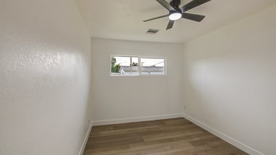 This bright bedroom offers updated flooring, fresh paint, ceiling fan, and natural light, making it ideal as a guest room, office, or additional sleeping space in Buckeye.