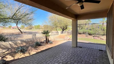 Covered patio featuring paver flooring, ceiling fan, screened enclosure, and peaceful views overlooking the golf course and professionally landscaped backyard. An ideal extension of the home's indoor living space.