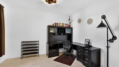 This dedicated office offers generous workspace, wood-look tile flooring, and plenty of room for working from home, studying, or creating a personalized flex space.