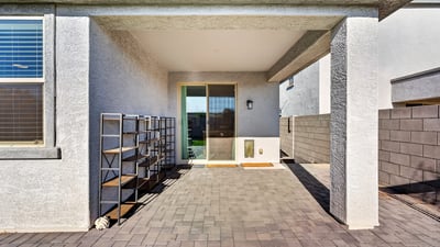 Covered patio with paver flooring and sliding glass door access creates an ideal extension of the great room for outdoor dining, entertaining, and relaxing.