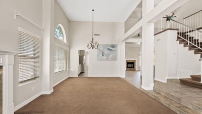 This generous living room offers soaring ceilings, oversized windows, and an open design that creates a bright, welcoming atmosphere. Perfect for everyday comfort or hosting family gatherings.