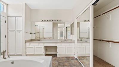 The primary ensuite features a dual-sink vanity, jetted soaking tub, spacious walk-in closet, and abundant cabinetry. Designed for comfort and convenience, it creates a relaxing owner's retreat.