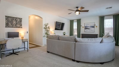 Spacious family room featuring a dedicated workspace, custom media wall, and comfortable seating area. This versatile room adapts easily to work, entertainment, and everyday living.