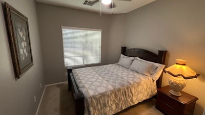 Comfortable bedroom featuring soft carpeting, ceiling fan, and natural light. A welcoming space that's ready to accommodate family, visitors, or remote work needs.