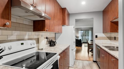 Modern kitchen featuring ample cabinet space, stainless steel appliances, and a seamless flow to the living area.