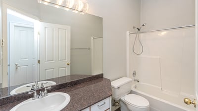 Well-appointed bathroom featuring dual sinks, modern fixtures, and a convenient tub-shower combination.