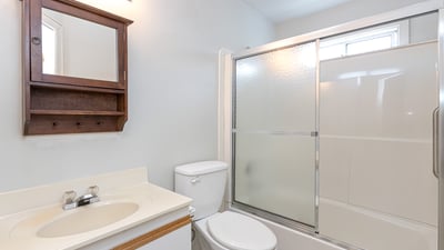 This well-equipped bathroom features a sleek shower enclosure and convenient storage space, perfect for everyday use.
