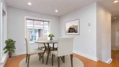 Bright and airy dining area featuring a modern table set and large windows for natural light.