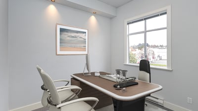 Modern office space featuring a sleek desk, ample natural light, and a minimalist aesthetic.