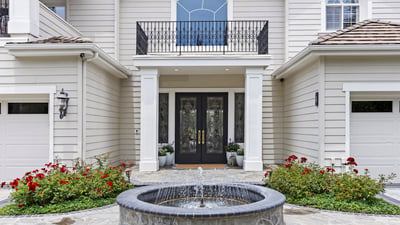 Elegant private entryway features a tranquil fountain and landscaped gardens, creating an inviting first impression.