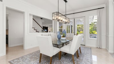 Bright dining area featuring large windows, modern lighting, and access to an outdoor patio space.