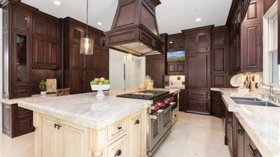 This gourmet kitchen features rich wood cabinetry, a spacious island, and premium appliances for culinary enthusiasts. 6 Burner Wolf Range with double ovens and griddle, 2 Bosch dishwashers, double sub zero fridges with 4 pull out freezer drawers, Wolf pull out microwave, tons of upgraded cabinets it pull out drawers, and so much more