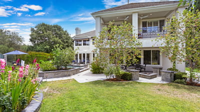 Spacious home with lush gardens, multiple outdoor seating areas, and a beautifully landscaped yard for relaxation.