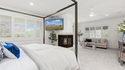 Primary Bedroom -Spacious bedroom with a cozy fireplace, adjacent sitting area, and abundant natural light throughout. (TV Included)