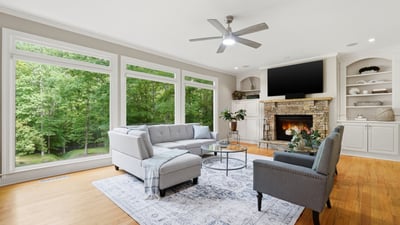 Bright and inviting living room featuring large windows, cozy fireplace, and spacious layout for entertaining.