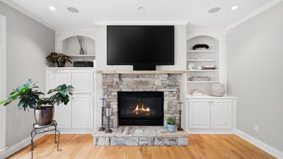 Cozy living space featuring a stone fireplace and built-in shelving, perfect for relaxation and entertainment.