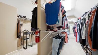 Spacious walk-in closet featuring abundant shelving for organized storage and natural light from skylights.