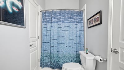 Bright and inviting bathroom featuring a colorful shower curtain and modern fixtures, perfect for daily use.