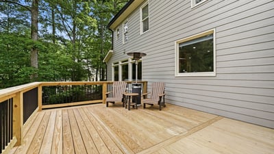 Spacious outdoor deck surrounded by trees, perfect for relaxing or entertaining in a private setting.
