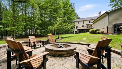 Gather around the fire pit in this spacious backyard, nestled among lush greenery and nature.