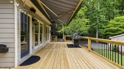 Spacious deck with awning, perfect for outdoor gatherings and overlooking lush green surroundings.