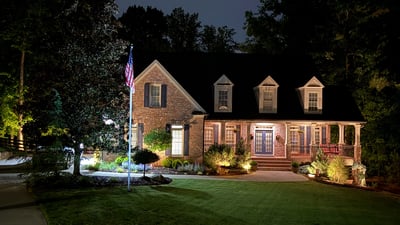 This beautifully illuminated home features inviting landscaping and ample outdoor space, perfect for evening gatherings.