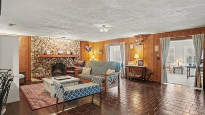 Living Room with large river rock, wood burning fireplace and gorgeous pecky cypress accent walls!