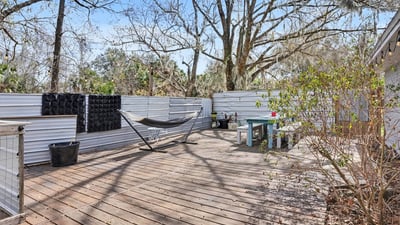 Large deck! This deck was custom built onsite and is really 4 separate decks to allow for easy repairs or board replacement. Set on concrete deck blocks that are strong enough to hold a 5-person spa or pool. Previous owners had both! Wooden walls surrounding the deck offer extensive privacy and are currently covered in metal for an outdoor space that's both kitschy and fun.