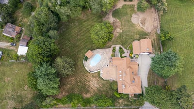 Spacious property featuring a pool, expansive lawn, and potential for development in a quiet neighborhood.