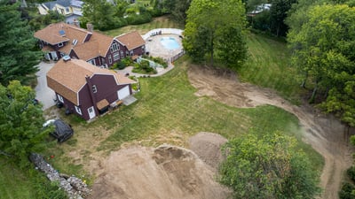 Spacious property featuring a large pool area, surrounded by lush greenery and ample outdoor space.
