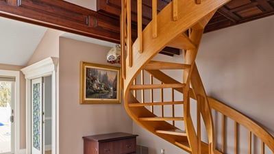 Discover a unique spiral staircase that enhances the inviting entryway of this modern home.
