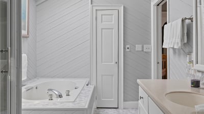Bright and airy bathroom featuring a skylight, spacious jacuzzi, and modern fixtures for a refreshing retreat.