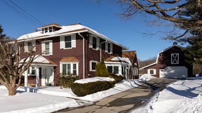 Spacious four-bedroom home with inviting exterior, expansive driveway, and a large garage on a snowy lot.