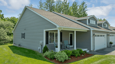 Welcoming home featuring a spacious front yard, ample natural light, and convenient parking.