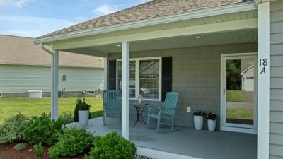 Inviting porch setup with greenery and seating, perfect for enjoying morning coffee in a quiet neighborhood.