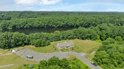 Spacious property with expansive parking and scenic river views, ideal for development or recreational use.