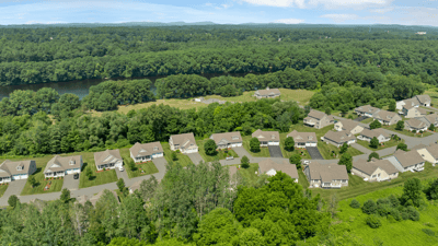 Stunning aerial view showcasing a desirable neighborhood surrounded by lush greenery and scenic river views.