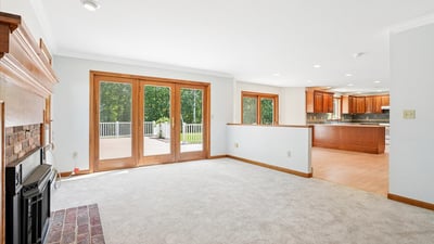 Bright open living space featuring a fireplace, large windows, and seamless access to outdoor entertaining.