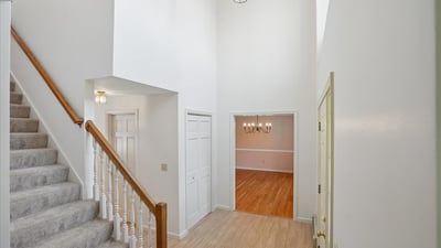 Spacious entryway featuring high ceilings and seamless flow to the inviting dining area and staircase.