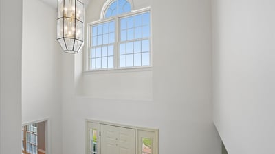 Expansive entryway featuring a statement light fixture and large windows that invite natural light.
