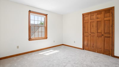 Bright and airy room featuring large windows, ample natural light, and well-crafted wooden closet doors.