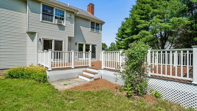 This spacious home features a large deck and lush backyard, perfect for outdoor gatherings and relaxation.