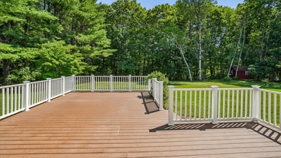 Spacious deck overlooking a large, private yard, perfect for outdoor gatherings and relaxation.