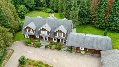 Spacious home surrounded by lush greenery, featuring multiple levels and ample outdoor space for recreation.