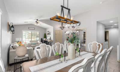 The spacious dining area features designer lighting, updated flooring, and a seamless connection to the living room, creating the perfect setting for everyday meals and special occasions.