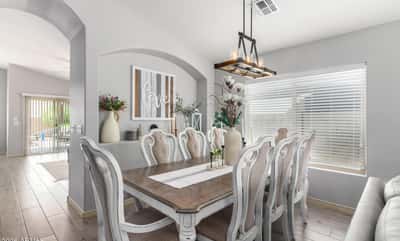 Gather family and friends in this spacious dining room featuring vaulted ceilings, designer lighting, updated flooring, and an open-concept layout that connects beautifully with the home's main living areas.