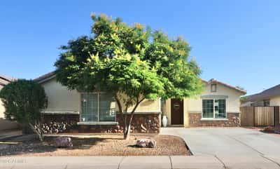 This attractive Buckeye home welcomes you with mature shade trees, stone-accented architecture, desert landscaping, and a spacious driveway leading to the attached two-car garage. Exceptional curb appeal makes a lasting first impression.